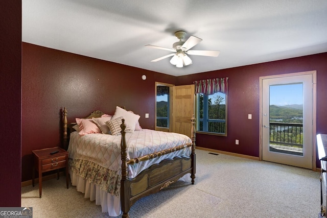 bedroom featuring access to exterior, light colored carpet, and ceiling fan