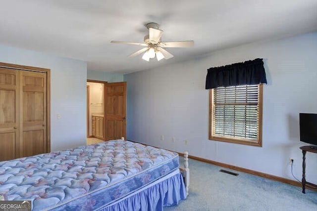 carpeted bedroom with ceiling fan and a closet