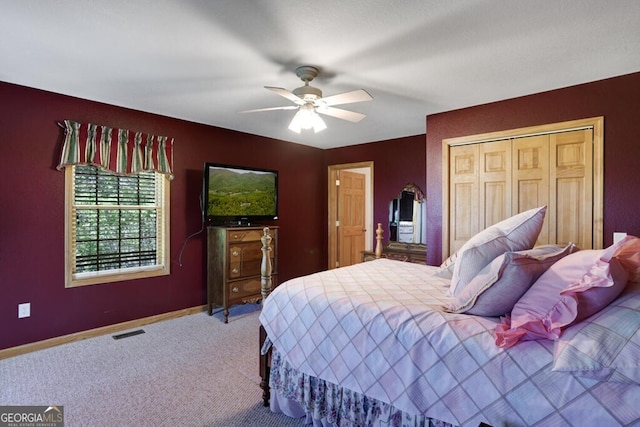 carpeted bedroom with ceiling fan and a closet