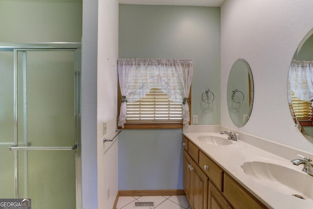 bathroom featuring tile patterned floors, vanity, and a shower with shower door