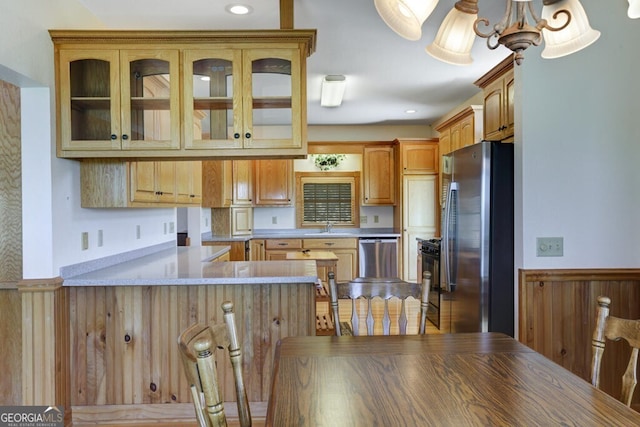 kitchen featuring kitchen peninsula, sink, appliances with stainless steel finishes, and a chandelier