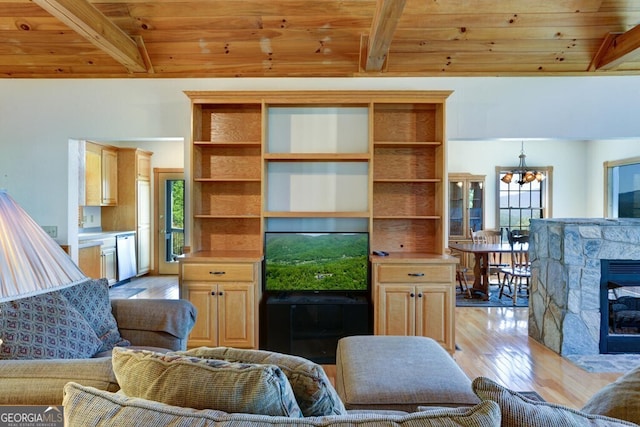 living room with light wood-type flooring, beam ceiling, wooden ceiling, a notable chandelier, and a fireplace