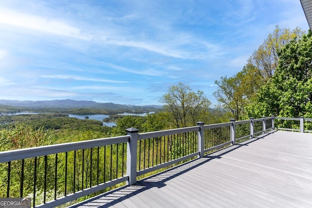 wooden terrace with a water and mountain view