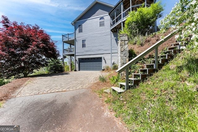 view of property exterior with a balcony and a garage