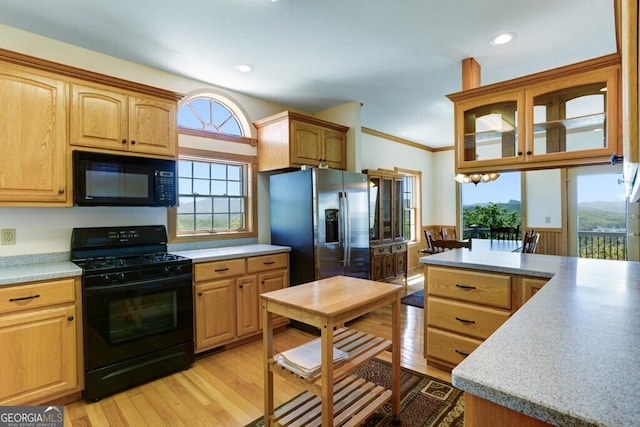 kitchen featuring black appliances, light hardwood / wood-style floors, and ornamental molding