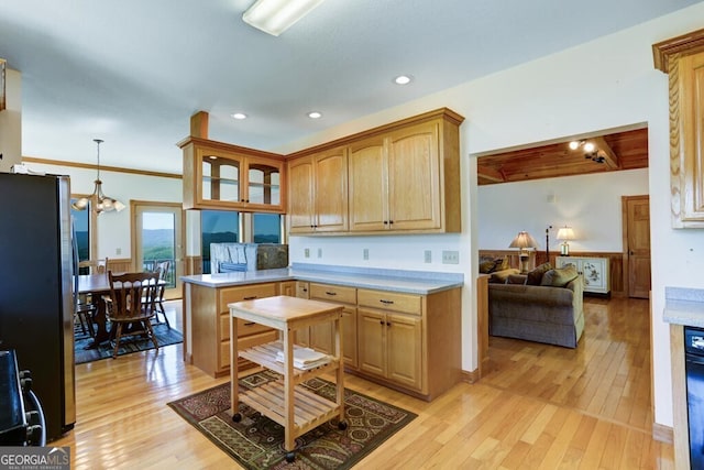 kitchen with kitchen peninsula, light wood-type flooring, stainless steel refrigerator, and hanging light fixtures