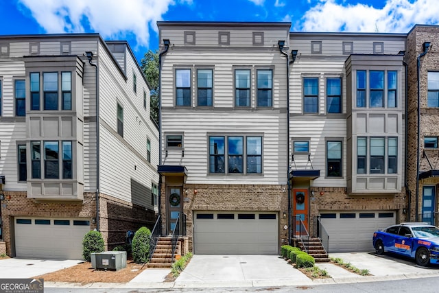 multi unit property featuring central AC unit and a garage