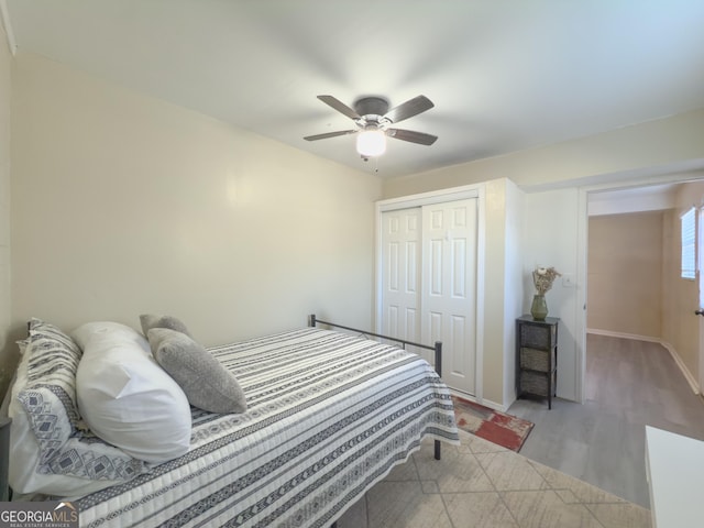 bedroom with ceiling fan, light wood-type flooring, and a closet