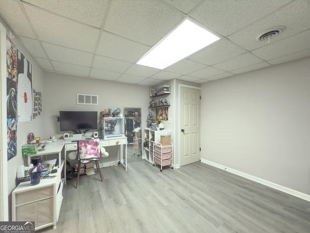 home office featuring a paneled ceiling and light hardwood / wood-style floors