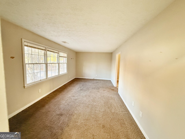 carpeted empty room with a textured ceiling