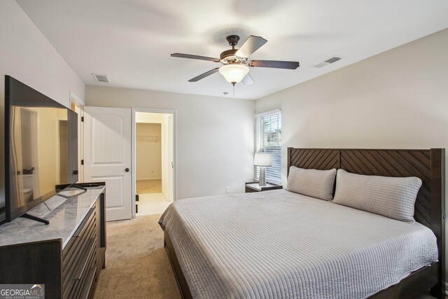 carpeted bedroom featuring a spacious closet, a closet, and ceiling fan