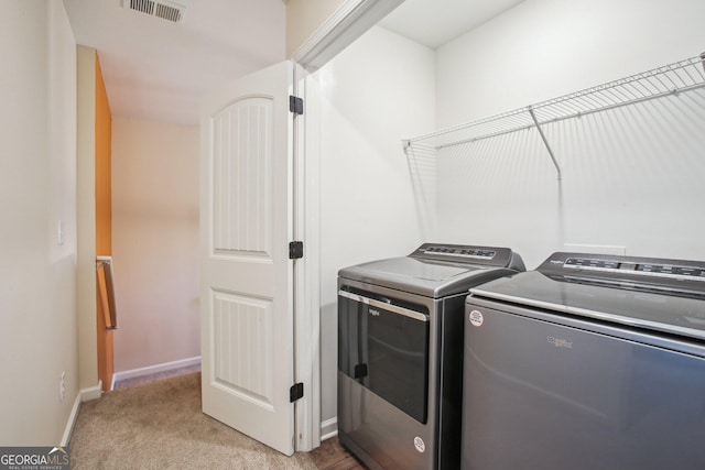 laundry room with light carpet and washer and dryer