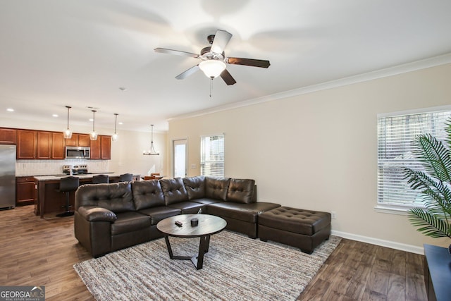 living room featuring hardwood / wood-style floors, ornamental molding, and ceiling fan