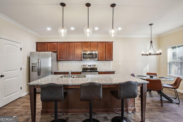 kitchen with backsplash, sink, hanging light fixtures, and appliances with stainless steel finishes