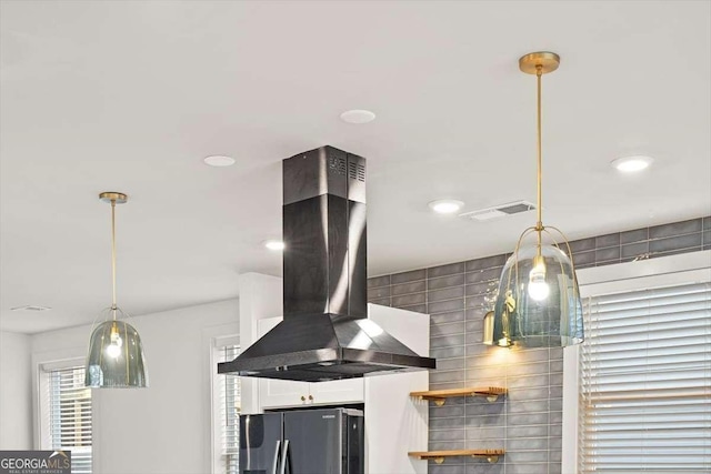 details featuring island exhaust hood and stainless steel fridge