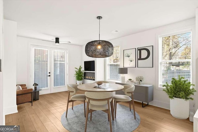 dining room with ceiling fan, light hardwood / wood-style floors, and a wealth of natural light