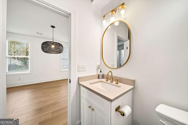 bathroom with vanity, hardwood / wood-style floors, and toilet