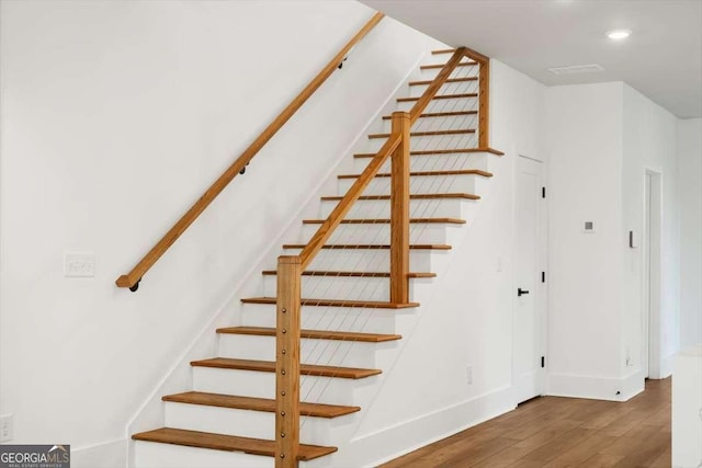 stairs featuring wood-type flooring