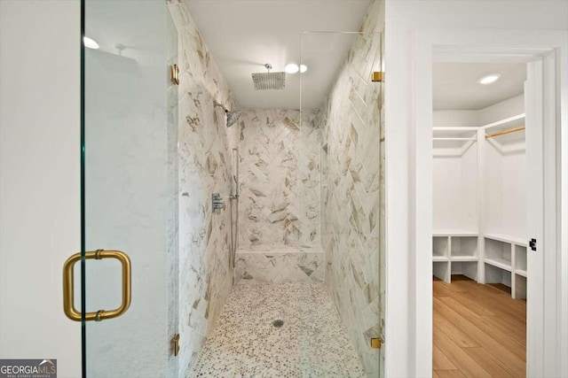 bathroom with hardwood / wood-style flooring and an enclosed shower