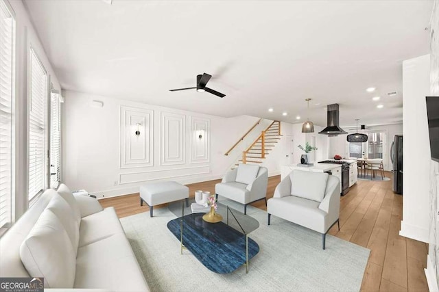 living room featuring light hardwood / wood-style floors and ceiling fan