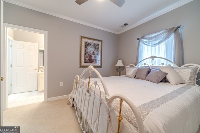 carpeted bedroom with ensuite bathroom, ceiling fan, and ornamental molding