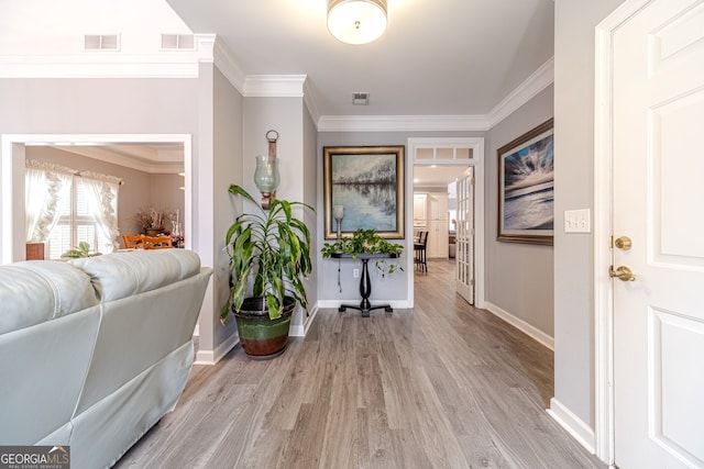 hallway with light wood-type flooring and ornamental molding