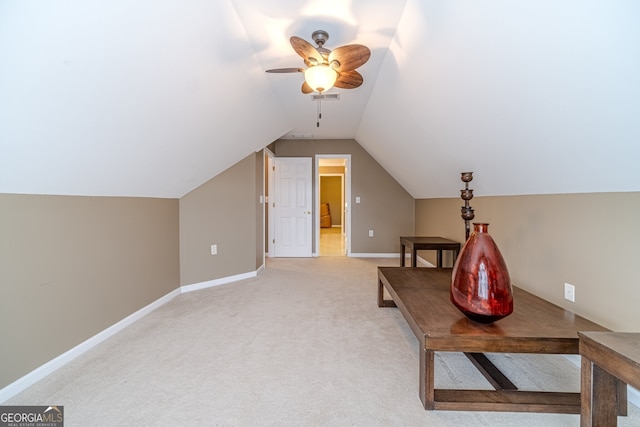 living area with ceiling fan, carpet, and lofted ceiling