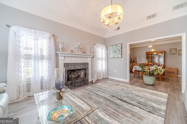 living room with a chandelier, light hardwood / wood-style floors, and plenty of natural light