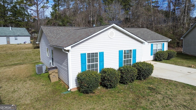 view of side of home featuring central AC unit and a lawn