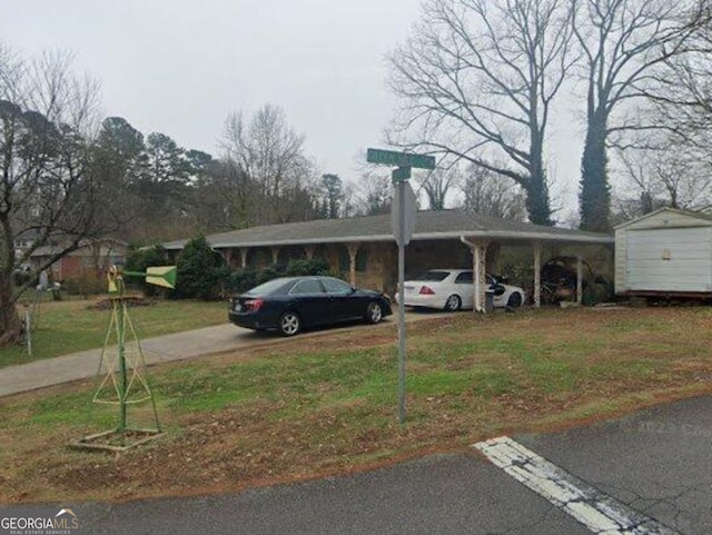 view of parking featuring a lawn and a carport