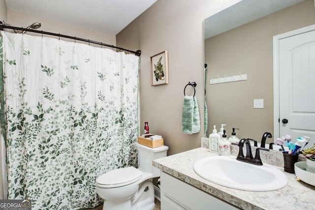 bathroom featuring walk in shower, vanity, and toilet