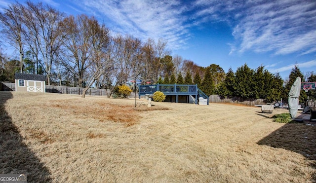 view of yard featuring a wooden deck and a storage shed