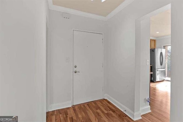 foyer with hardwood / wood-style flooring and crown molding