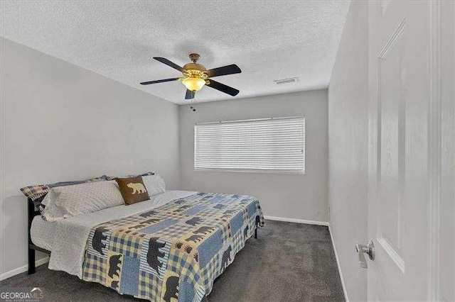 carpeted bedroom featuring ceiling fan and a textured ceiling