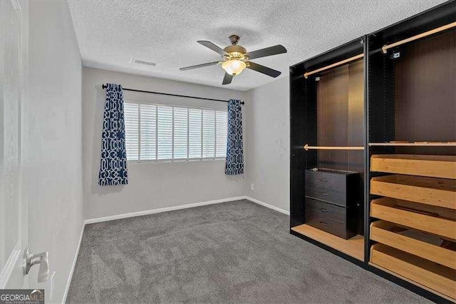 unfurnished bedroom featuring ceiling fan, a closet, dark carpet, and a textured ceiling