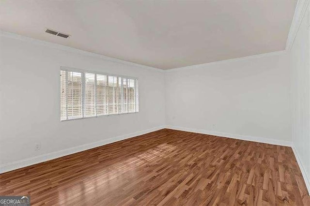 unfurnished room featuring hardwood / wood-style flooring and ornamental molding