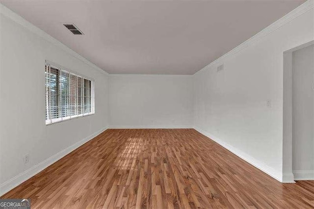 unfurnished room with wood-type flooring and ornamental molding