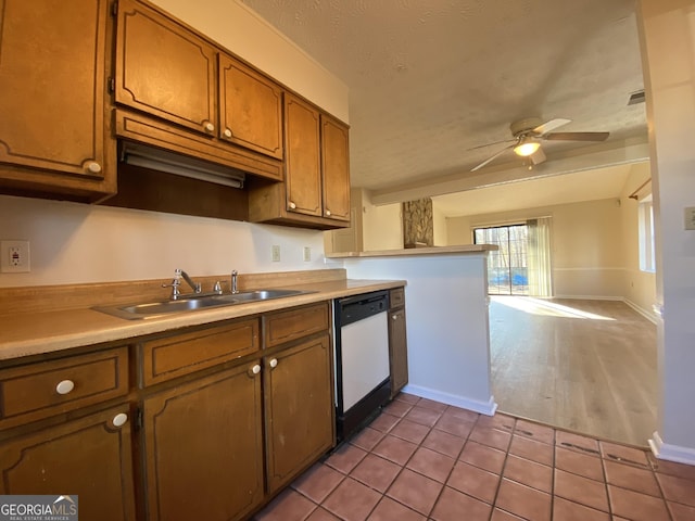 kitchen featuring ceiling fan, dishwasher, sink, a textured ceiling, and light tile patterned floors