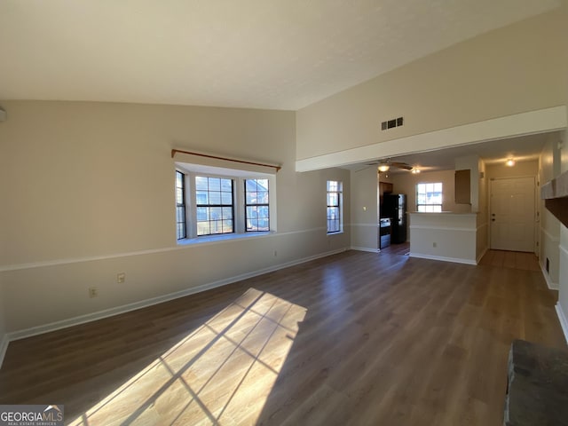 unfurnished living room with ceiling fan, dark wood-type flooring, and vaulted ceiling