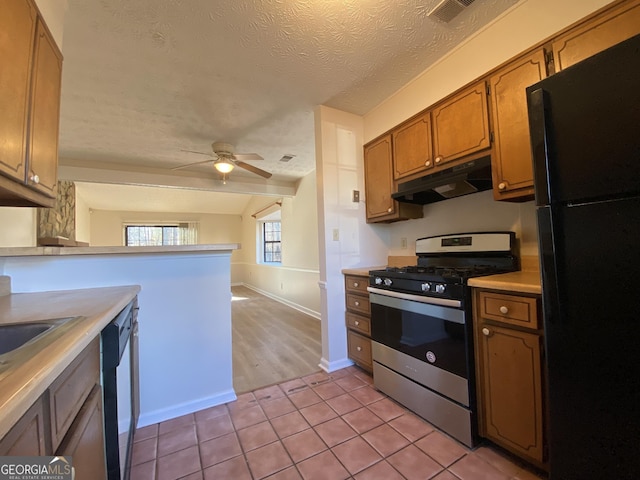 kitchen with gas range, ceiling fan, dishwasher, black fridge, and a textured ceiling