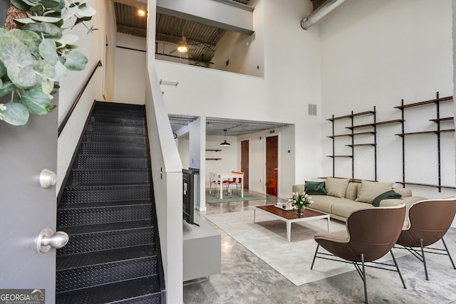 stairway with visible vents and a towering ceiling