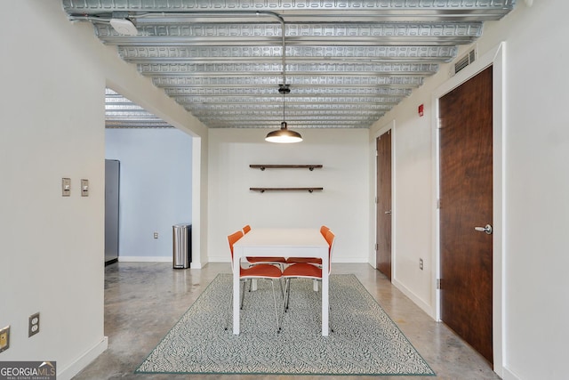 dining space with concrete floors and baseboards