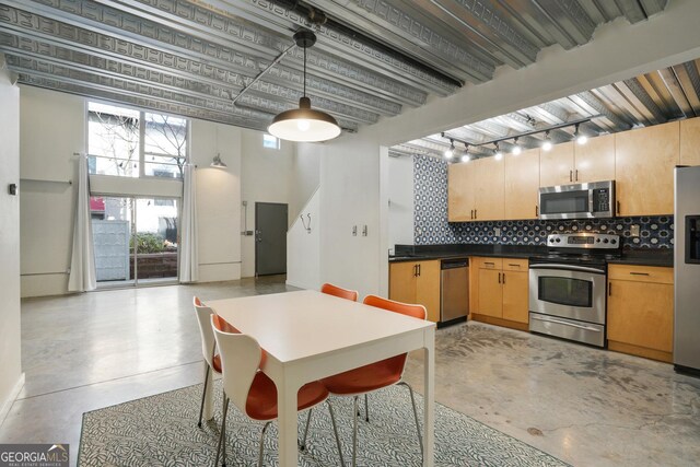 kitchen with appliances with stainless steel finishes, backsplash, and concrete floors