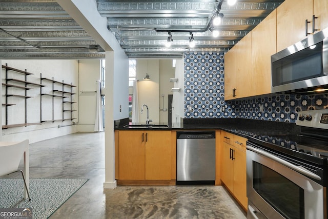 kitchen featuring appliances with stainless steel finishes, dark countertops, concrete flooring, and a sink