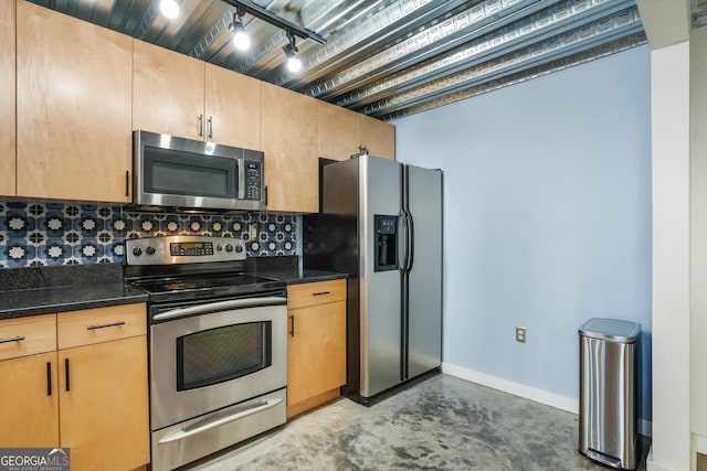 kitchen with stainless steel appliances, concrete floors, baseboards, decorative backsplash, and track lighting