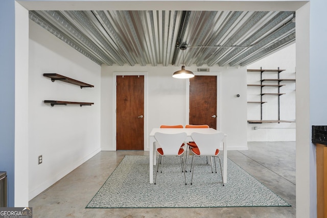 unfurnished dining area with finished concrete floors, visible vents, and baseboards