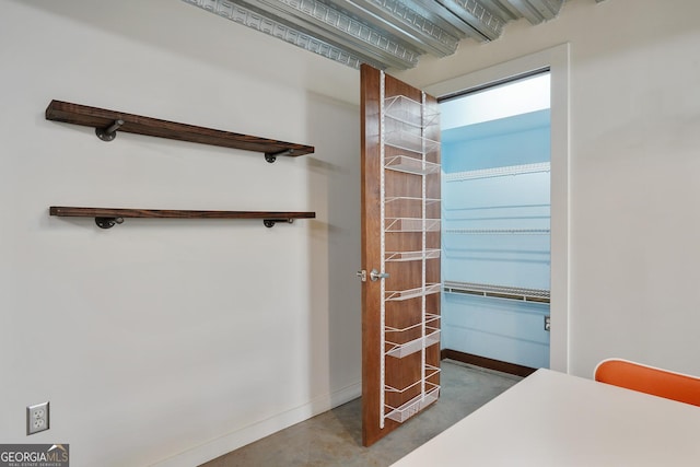 interior space featuring concrete floors and baseboards