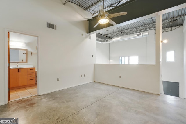 garage with baseboards, ceiling fan, visible vents, and a sink