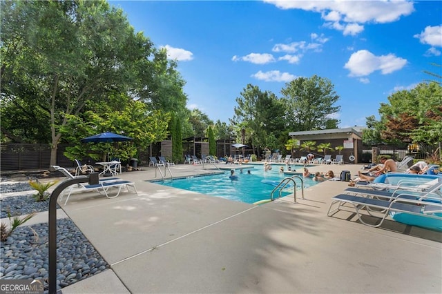 pool with a patio and fence