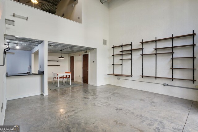 unfurnished living room with a towering ceiling and concrete floors